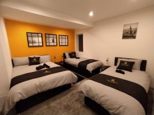 pokój z 3 łóżkami w pokoju w obiekcie Black Pearl Luxury Apartments w Blackpool