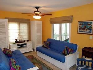 a living room with a blue couch and windows at Beautiful Apartment with Terrace in Contadora