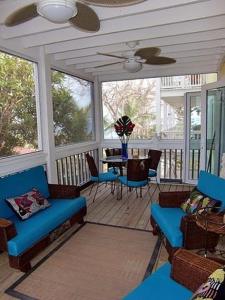 un porche cubierto con sillas azules y una mesa en Beautiful Apartment with Terrace, en Contadora