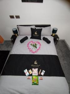 a bed with a black and white comforter with a heart shapedvisor at Black Pearl Luxury Apartments in Blackpool