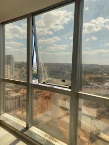 an open window with a view of a city at Flat encantador com piscina e área de lazer in Brasilia