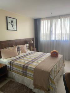 a bedroom with a large bed and a window at Flat encantador com piscina e área de lazer in Brasília