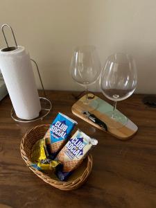 a basket of chips and wine glasses on a wooden table at Flat encantador com piscina e área de lazer in Brasilia