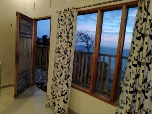 a room with a view of a balcony with windows at Bara Village Guest House Bira in Bira