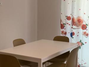 una mesa blanca y sillas en una habitación con cortina en Villa Samadoel, en Santa Maria del Focallo