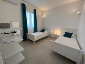1 Schlafzimmer mit 2 Betten und einem Fenster mit Vorhängen in der Unterkunft Villa Samadoel in Santa Maria Del Focallo