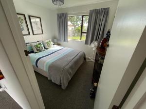 1 dormitorio con cama y ventana en Greenmeadows Napier & Pet Friendly, en Napier