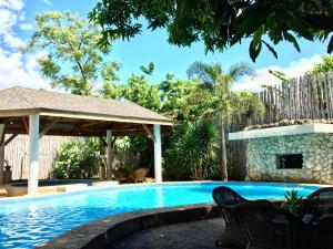uma piscina com um gazebo em Lapu-Lapu Cottages & Restaurant em Mactan