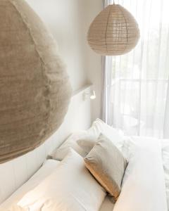 a bedroom with a bed with white pillows and a window at Aquabelle Apartments in Rye