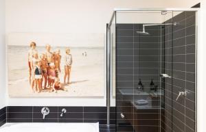 a bathroom with a picture of a family on the beach at Aquabelle Apartments in Rye