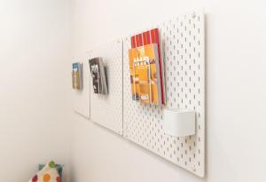 una estantería blanca montada en la pared con libros en Aquabelle Apartments, en Rye