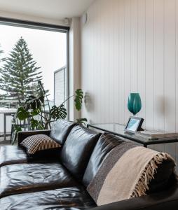 a black leather couch in a living room with a window at Aquabelle Apartments in Rye