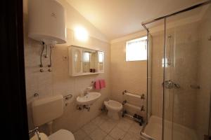 La salle de bains est pourvue d'un lavabo, de toilettes et d'une douche. dans l'établissement Apartments by the sea Seline, Paklenica - 6531, à Starigrad-Paklenica