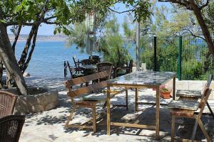 a table and chairs and a table and a table and water at Apartments and rooms by the sea Seline, Paklenica - 6440 in Starigrad-Paklenica