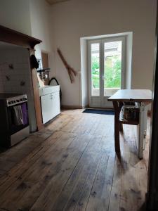 cocina con suelo de madera y mesa en L'Aile Ouest de la Piraterie, en Bergerac