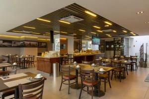 a restaurant with tables and chairs and a bar at Hotel Capital Bellet in Santiago