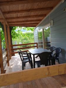 a patio with a table and chairs on a deck at Mobile home Comfort Ameglia - including airco - Camping River- 327 in Ameglia