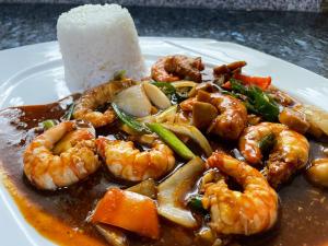 un plato de camarones y otros alimentos en una mesa en Lapu-Lapu Cottages & Restaurant, en Mactan