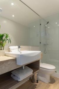 a white bathroom with a sink and a toilet at Hotel Capital Bellet in Santiago +53 photos