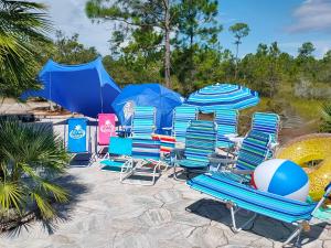 佩爾迪多基的住宿－Luxury Vacation Home near Johnson Beach，海滩上的一组椅子和遮阳伞