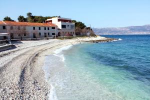 a beach with some buildings and the water at Apartments by the sea Slatine, Ciovo - 7544 in Slatine