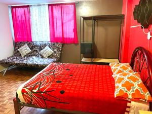 a bedroom with a red bed and a couch at B&B México Roma Norte in Mexico City