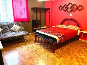 Dormitorio rojo con cama y sofá en B&B México Roma Norte, en Ciudad de México