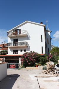 a white building with a balcony and some flowers at Apartments with parking space Zadar - Diklo, Zadar - 6453 in Diklo