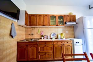 a kitchen with wooden cabinets and a sink and a refrigerator at Apartments with parking space Zadar - Diklo, Zadar - 6453 in Diklo +16 photos
