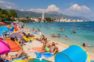 grupa ludzi na plaży w wodzie w obiekcie Apartments by the sea Kastel Stafilic, Kastela - 8621 w mieście Kaštela