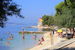 a group of people in the water at a beach at Apartments by the sea Kastel Kambelovac, Kastela - 8627 in Kaštela