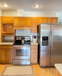 a kitchen with a stainless steel refrigerator and wooden cabinets at Delightful 3 Bdrm Home, Mins to Clearwater Beach in Clearwater