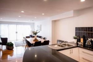 a kitchen and living room with a table and a dining room at Chic Harbourside Group Haven in Heart of Hobart in Hobart