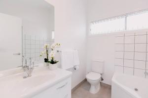Un baño blanco con inodoro y lavabo. en Spacious Townhouse Comfort in Hobart's Heart, en Hobart 12 fotos más