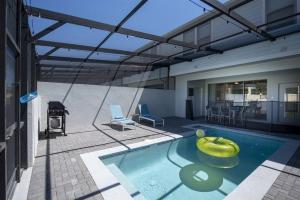 een zwembad met een gele kom in een huis bij Amazing 5 Bedrooms Home With Pool/BBQ Near Disney in Kissimmee