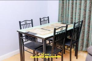 tavolo nero da pranzo con 4 sedie di Luxe Furnished Apartments a Meru