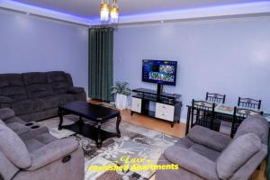 salon z kanapami i telewizorem z płaskim ekranem w obiekcie Luxe Furnished Apartments w mieście Meru