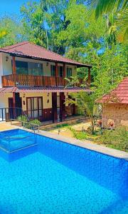 a house with a swimming pool in front of a house at Lakefront Beach Homes in Cherai Beach