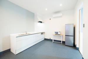 a kitchen with white cabinets and a refrigerator at the circle apartment in Shima