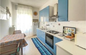 uma cozinha com armários azuis e uma mesa com um sidx de mesa em 1 Bedroom Amazing Apartment In Castro em Minervino di Lecce