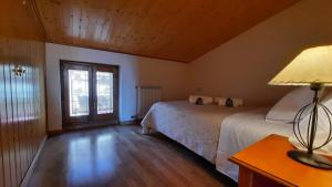 1 dormitorio con 2 camas y mesa con lámpara en ESPECTACULAR CASA RURAL CA L'ESQUERRÉ, en Cerviá