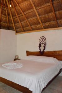 a bedroom with a white bed with a wooden headboard at Aldea Che-Eek , con acceso a un club de playa privado in Bacalar