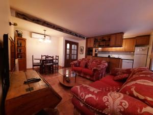 ESPECTACULAR CASA RURAL CA L'ESQUERRÉ في Cerviá: غرفة معيشة مع أريكة حمراء وطاولة