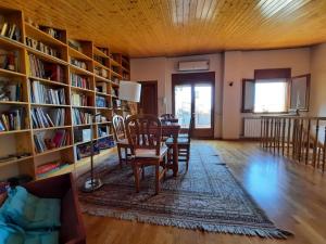 ein Wohnzimmer mit einem Tisch, Stühlen und Bücherregalen in der Unterkunft ESPECTACULAR CASA RURAL CA L'ESQUERRÉ in Cerviá