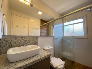 y baño con lavabo, ducha y aseo. en LOCAR-IN GRAMADO- 100m Rua Coberta, en Gramado