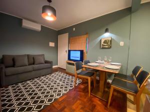uma sala de estar com uma mesa e um sofá em LOCAR-IN GRAMADO- 100m Rua Coberta em Gramado