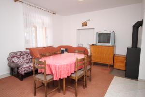 a room with a table and chairs and a tv at Apartments with a parking space Seline, Paklenica - 6628 in Starigrad