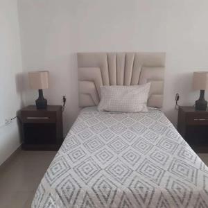 a bedroom with a bed with two nightstands and two lamps at Casa-Posada in Cajamarca +3 photos