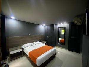 - une chambre avec un grand lit et un miroir dans l'établissement Hotel Latino Medellín, à Medellín