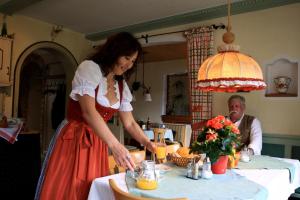 a woman standing in front of a table with a man at Ferienwohnungen Gästehaus Sonnenkreis in Ruhpolding +29 photos